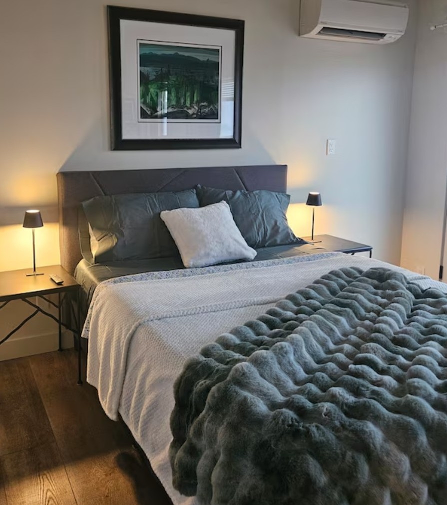 A guest bed at Global Village made up with a crisp white bedspread and bright pillows